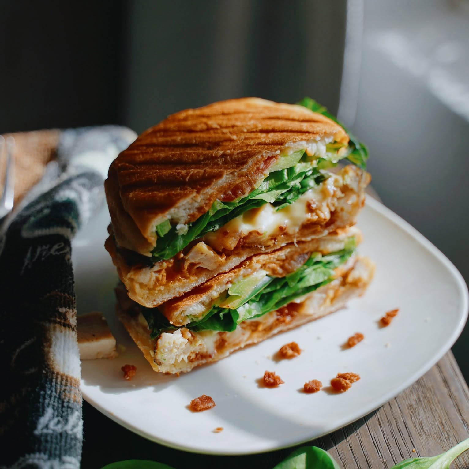 Grilled chicken panini with melted cheese, avocado and greens